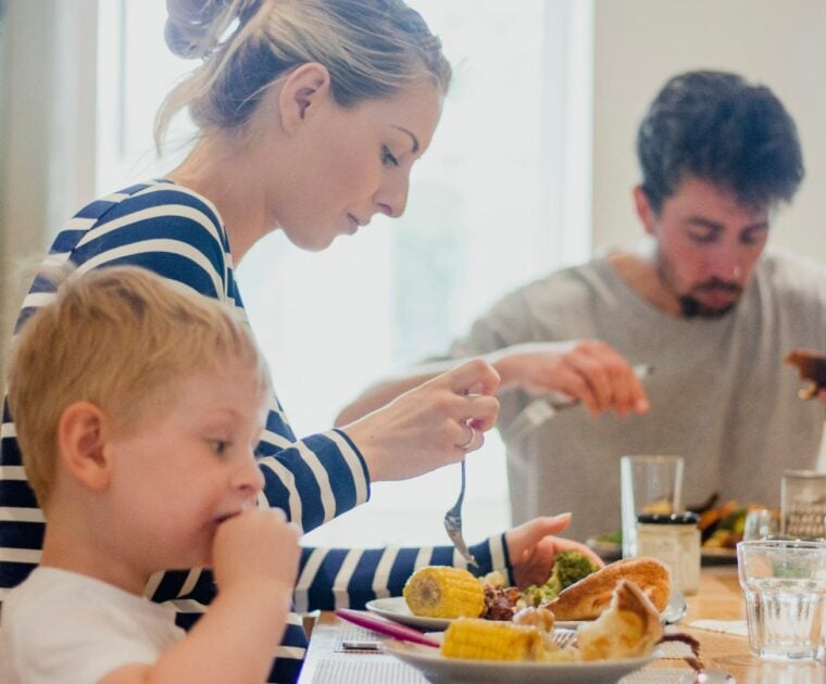 Family eating dinner at the dining table together, with mum, dad and young boy